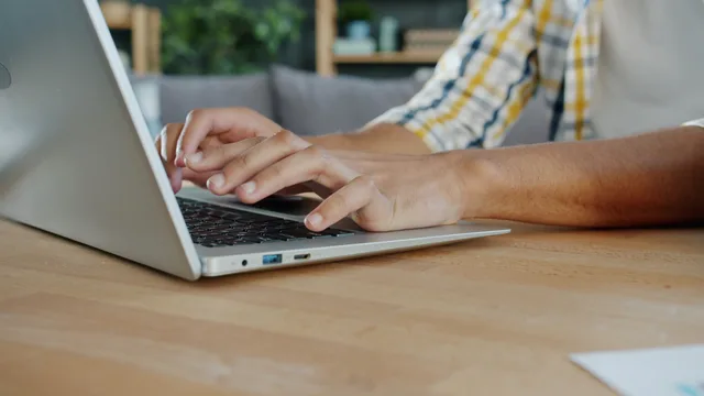 Close-up of hands typing on a laptop indoors, ideal for business and tech themes. Email marketing software reporting dashboard: what to show