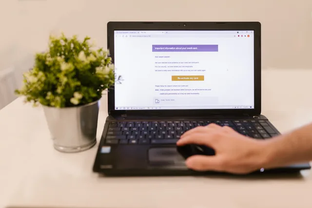 Person using a laptop to read an email indoors beside a potted plant. A task-based forecast of email software skills to 2027, not imagined vacancies
